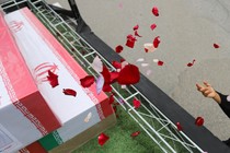 In this picture obtained from Iran's ISNA news agency, a mourner sprays flower petals on the coffins of children who were killed in a reported strike on a primary school in Iran's Hormozgan province during a funeral in Minab on March 3, 2026.