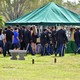 People are seen walking outside of a tent 