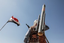 A Houthi fighter from behind, with a weapon on his back and militia insignia