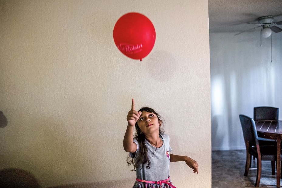 Lily plays with a balloon at home.