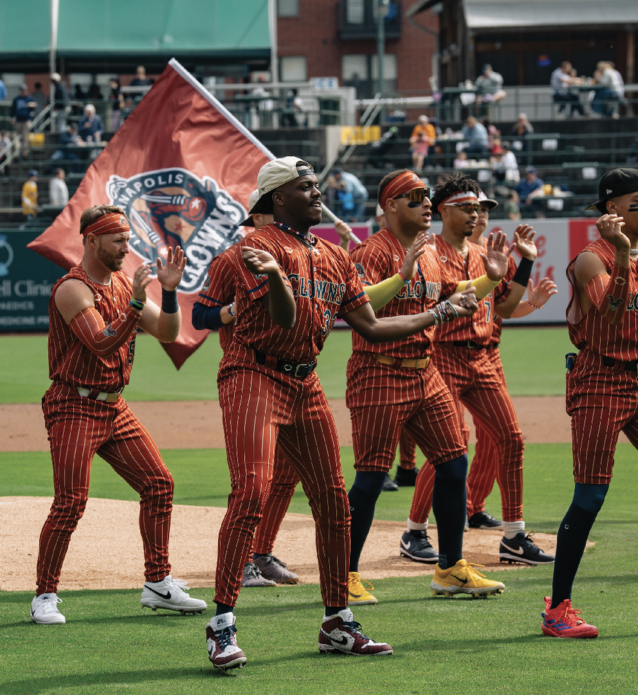 photo of uniformed players doing dance moves while one waves a flag