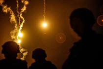 Taiwanese soldiers silhouetted against flares in the night sky