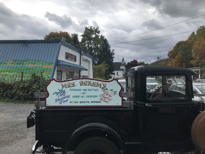 An old-timey truck with a sign advertising Arbor Hill Grapery.