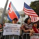 People hold North Korean and American flags near Hanoi's Metropole hotel, where Donald Trump and Kim Jong Un were meeting.