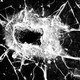 A photo of window glass splintered by a bullet impact.