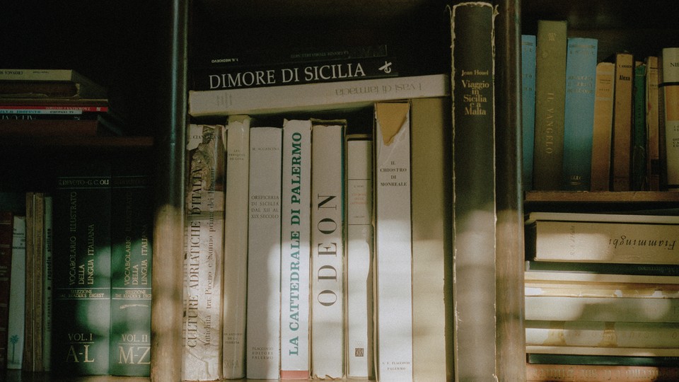 A vertical row of books surrounded by books in horizontal arrangements