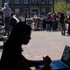 A college student works on her computer with pro-Palestinian protestors in the background.