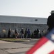 voters lining up outside of voting location with U.S. flag