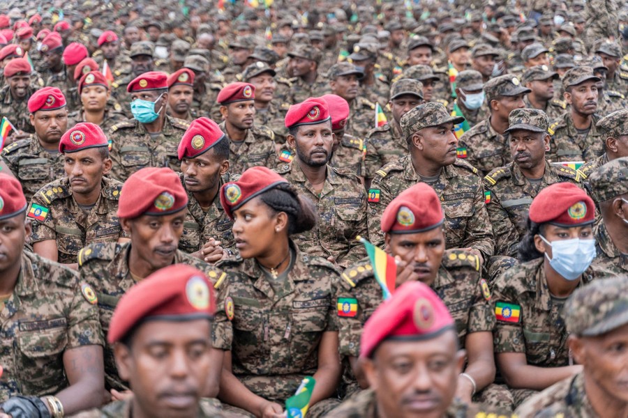 Dozens of Ethiopian soldiers sit together in uniform.