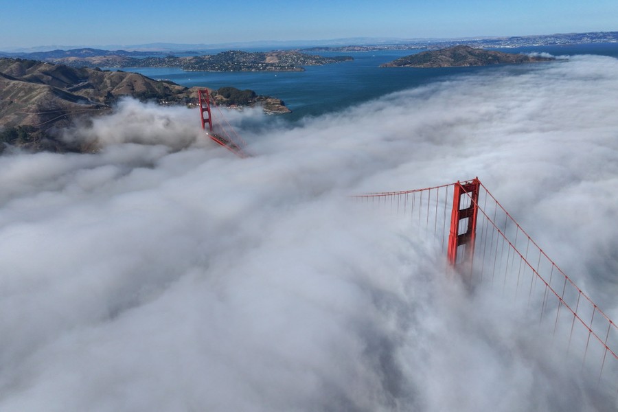 An aerial view of fog surrounding the Golden Gate Bridge