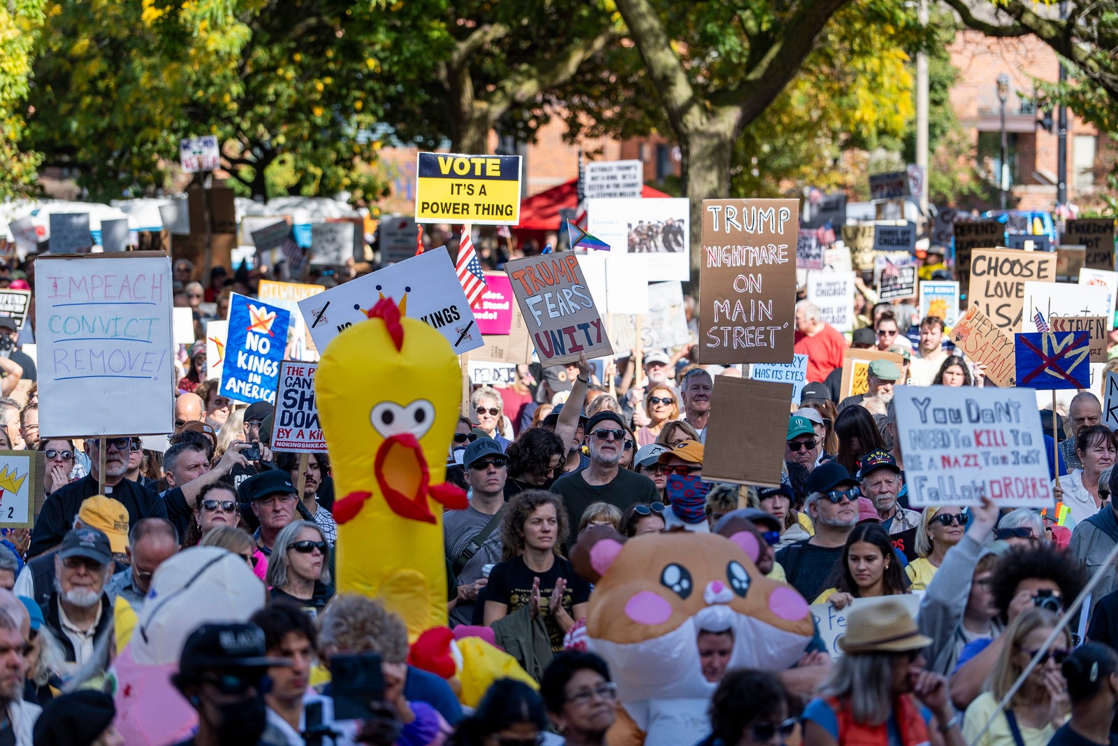 Protesters march and carry signs, including several wearing inflatable animal costumes.