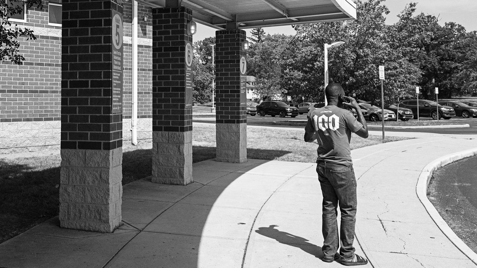 A Haitian father on the phone outside an elementary school