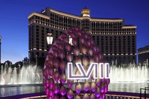 A display of footballs with a Super Bowl LVIII logo in front of the fountains of Bellagio