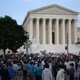 a crowd of activists rally in front of the U.S. Supreme Court buildi