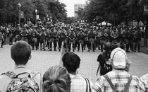 A photo of student protesters facing off against riot police.