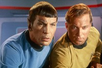 Spock and Captain James T. Kirk lean in to look intently at a screen