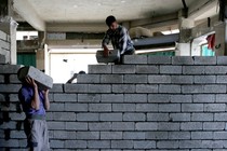 Two workers lay stones in order to rebuild a shop that was destroyed during fighting between Iraqi forces and Islamic state fighters in Mosul, Iraq.