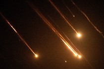 A color photo of missiles streaking across a night sky