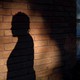 A woman's silhouette on a brick wall
