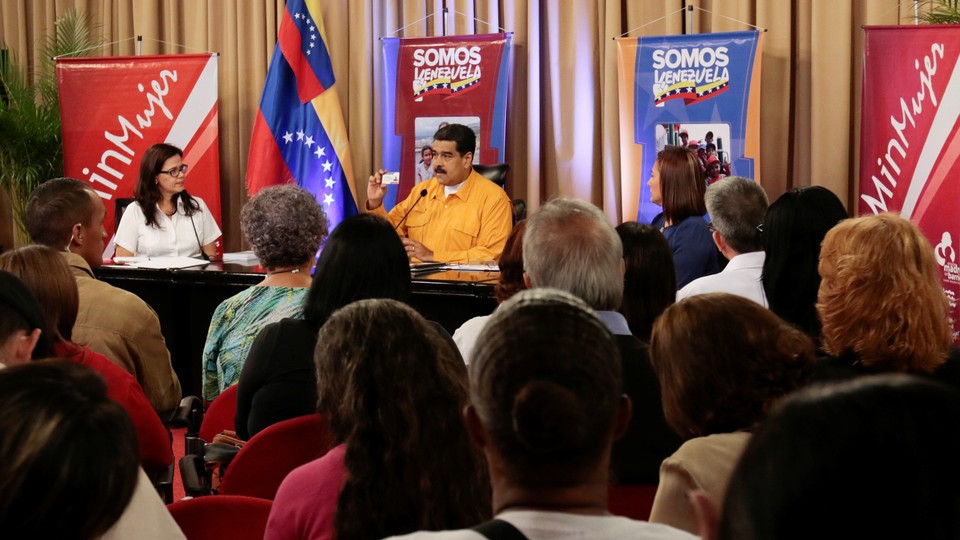 Maduro holds a copy of the constitution during a meeting with supporters on July 11, 2017. 