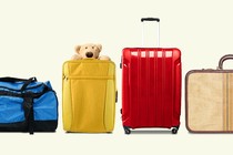 four different suitcases, one with a stuffed animal poking out