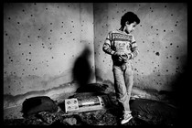 A black-and-white photo of a Palestinian boy in Gaza