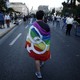 A gay-rights activist wearing a rainbow flag walks through the city center during a Gay Pride parade.