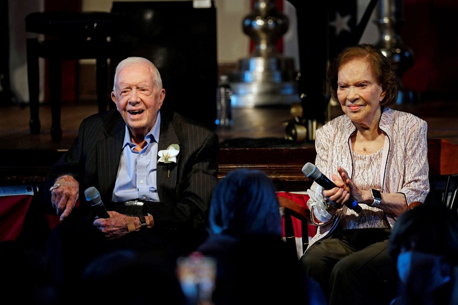 Jimmy and Rosalynn Carter sit side-by-side before an audience.