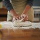 A woman kneads bread