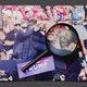 A magnifying glass over an image of a blooded Trump