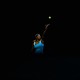 A photo of Serena Williams with a black backdrop tossing a ball