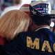 Photo showing woman resting her head on the shoulder of a man wearing "Trump 2024" cowboy hat and a jacket that reads MAGA