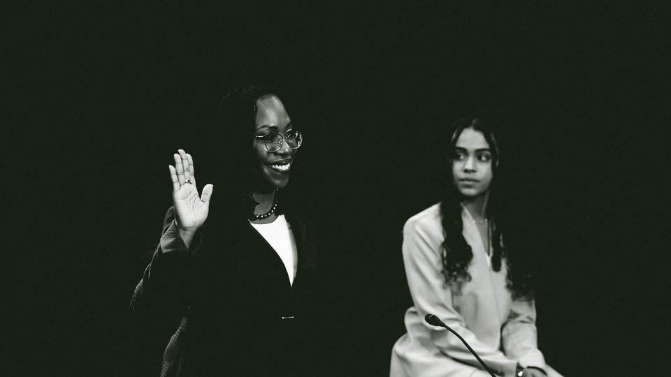 Kentaji Brown Jackson raises her right hand at her confirmation hearings while her daughter looks on