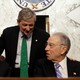 Senator John Kennedy (standing) speaks with Senators Orrin Hatch (left) and Chuck Grassley.