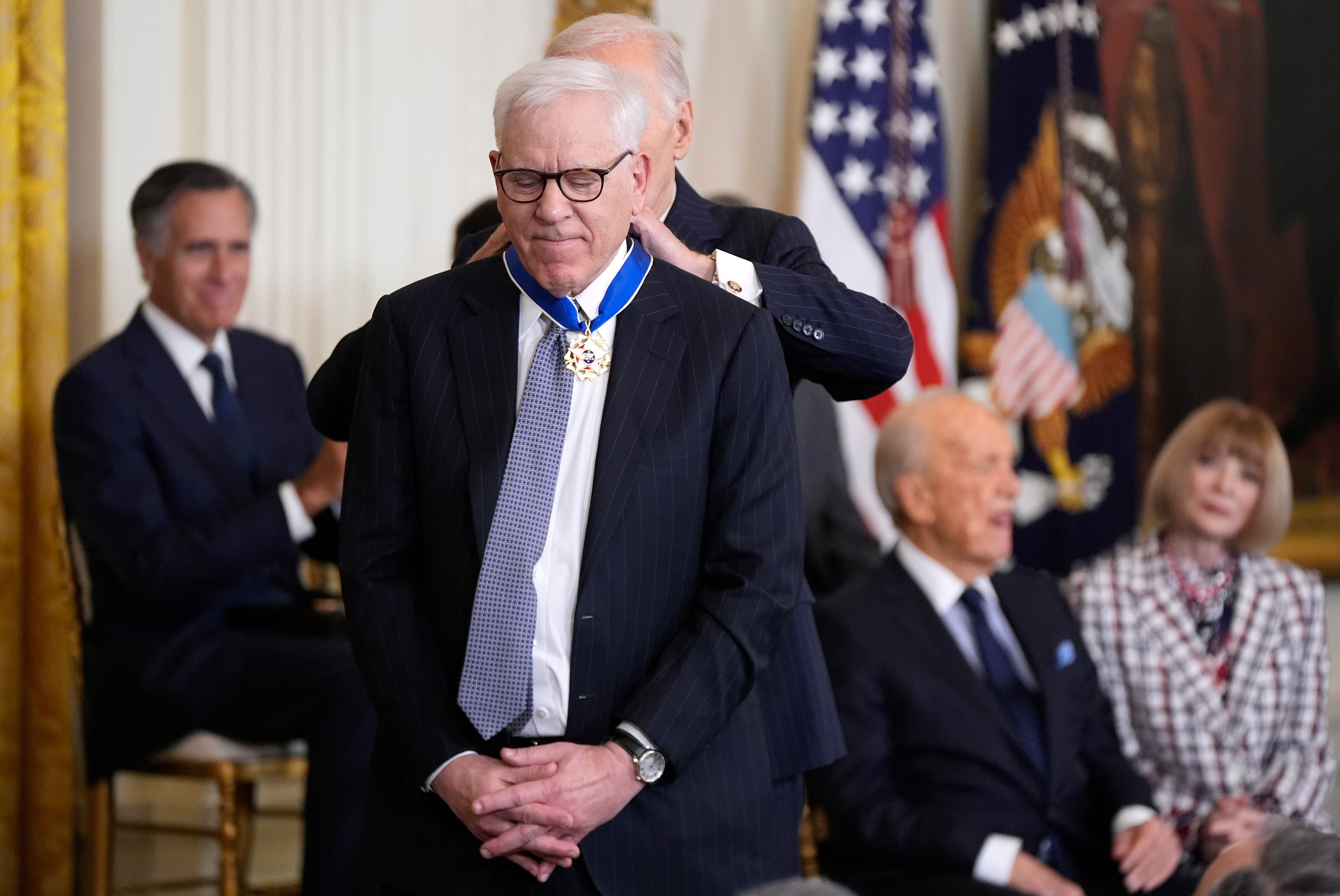 Rubenstein standing on a stage receiving  the Presidential Medal of Freedom from President Joe Biden
