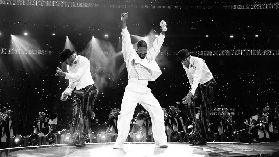 Usher dancing on stage at the Super Bowl half time show