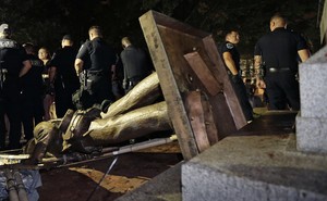 On Monday, August 20, 2018, police stand guard after the Confederate statue known as Silent Sam was toppled by protesters on campus at the University of North Carolina in Chapel Hill, North Carolina.