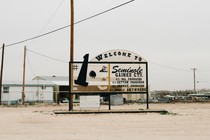 A welcome sign for Seminole Texas stands in a dirt lot