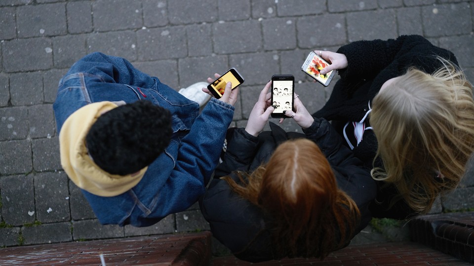 Three people looking at their phones