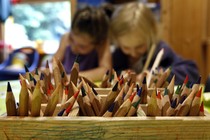 Two children draw with colored pencils 