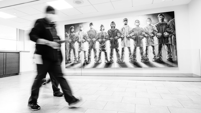 Hospital staff walk by a "Frontline Warriors" mural at Long Island Jewish Medical Center