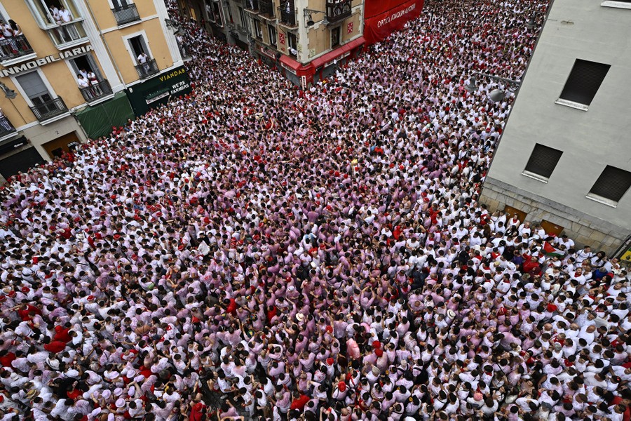 A view from a balcony, looking down on a huge crowd of people packed into a town square.