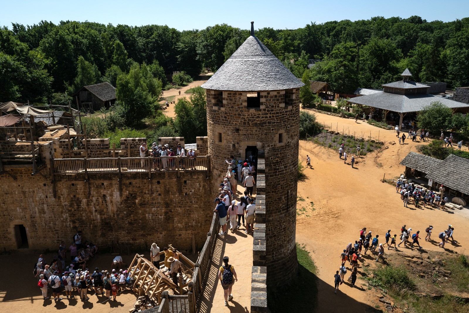 Visitors walk the grounds and castle walls at the construction site.
