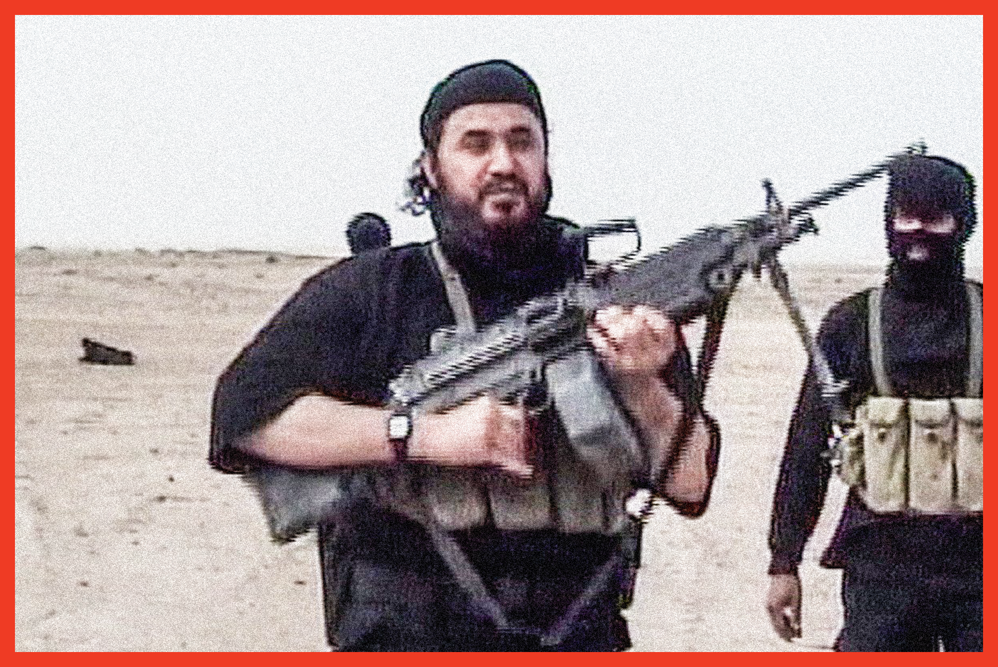 video still of man wearing black head scarf and clothing with black beard, carrying rifle and wearing a belt with many pouches, in desert landscape