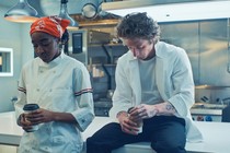 Ayo Edebiri and Jeremy Allen White next to each other holding coffee cups