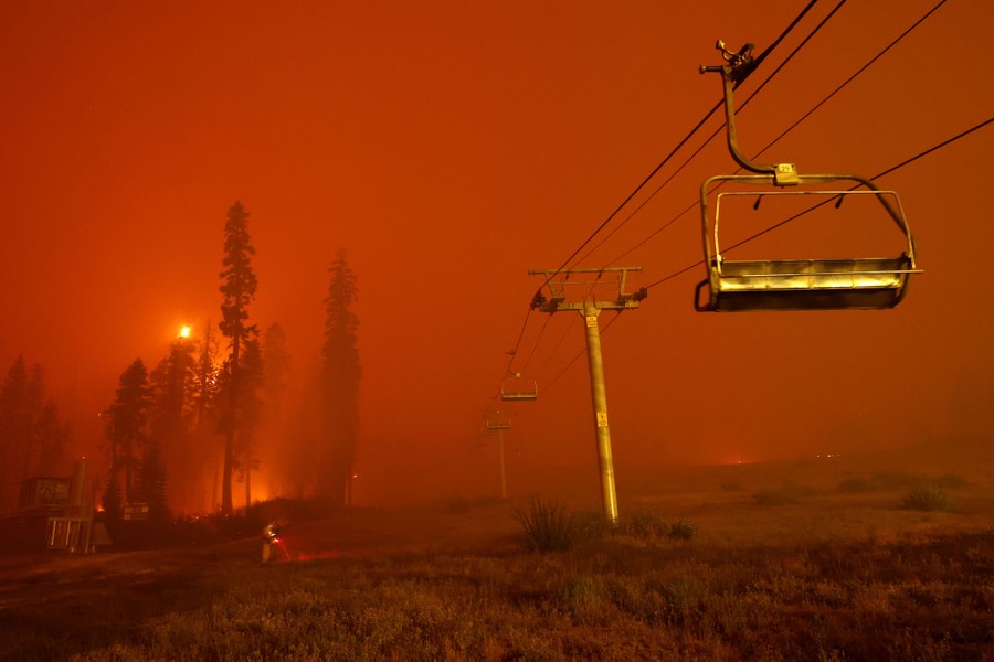 Smoke and a forest fire are seen near a chairlift.