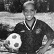 Writer Clint Smith, as a child, holding a soccer ball and grinning while wearing a jersey