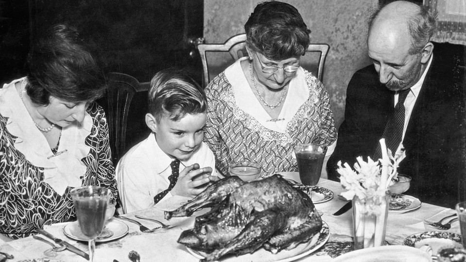 A family says grace before Thanksgiving dinner in the 1930s.