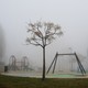 Fog surrounds an empty playground.