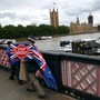 An anti-Brexit campaigner crosses a bridge opposite Parliament in London holding a "Stop Brexit" sign.